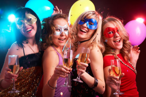 Portrait of happy young girls under masks on the party